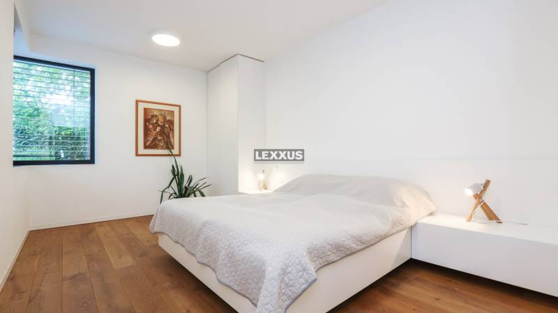 Schlafzimmer in einem Einfamilienhaus mit Holzboden, Bild und Nachttisch.