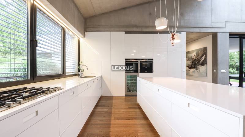 Küche in einem Einfamilienhaus mit weißen Schränken und Holzboden.