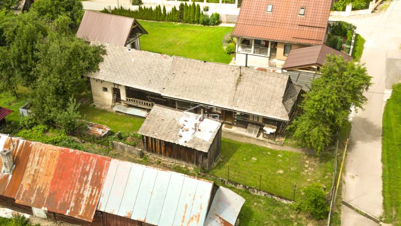 Eine rustikale Hütte in Papradno, umgeben von Grün und Nebengebäuden.