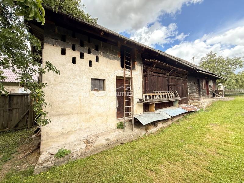 Ein Blick auf eine ältere Hütte in Papradno mit Holzkonstruktion und gepflegtem Hof.
