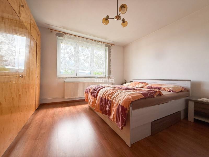 Ein Schlafzimmer in einem Einfamilienhaus mit einem Doppelbett und einem großen Kleiderschrank.