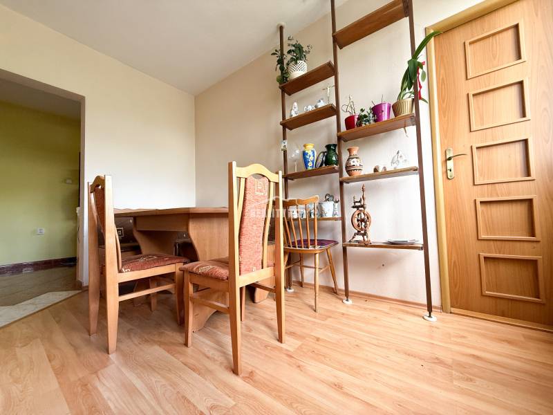 Esszimmer in einem Einfamilienhaus mit Holztisch, Stühlen und dekorativen Regalen.