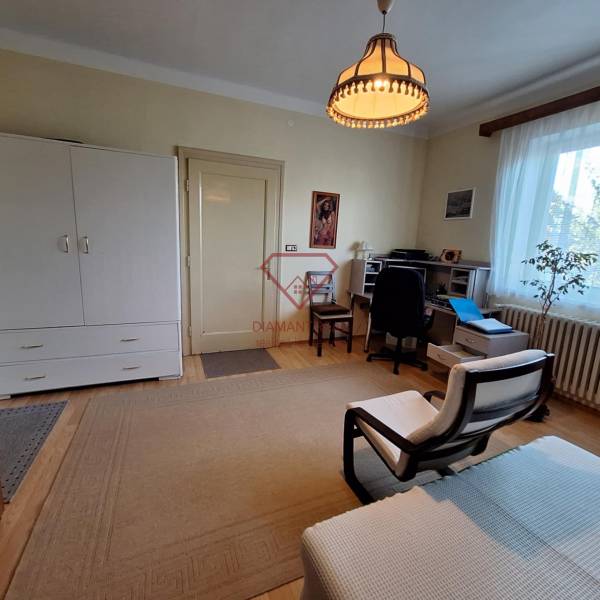 Wohnzimmer in einem Einfamilienhaus mit Sessel, Schreibtisch und Kommode.