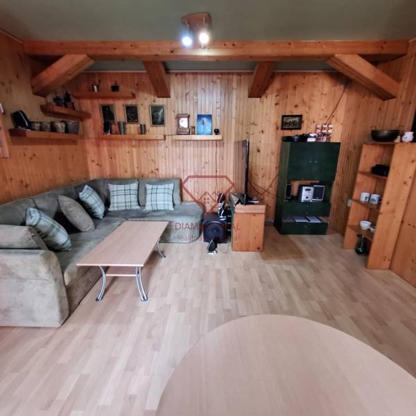 Gemütliches Wohnzimmer mit Holzverkleidung, Sofa und Tisch in einem Einfamilienhaus.