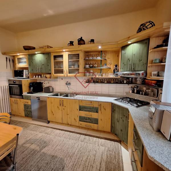 Küche in einem Einfamilienhaus mit Holzschränken und Küchengeräten.