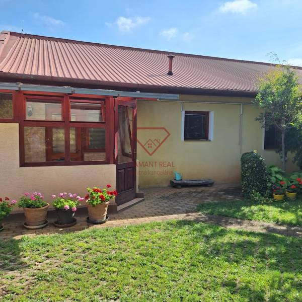 Ein Einfamilienhaus in der Šalská-Straße in Šaľa mit Garten und Blumen.
