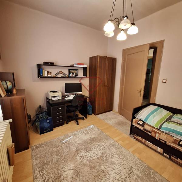 Ein Zimmer in einem Einfamilienhaus mit einem Schreibtisch, einem Bett und einem Kleiderschrank.