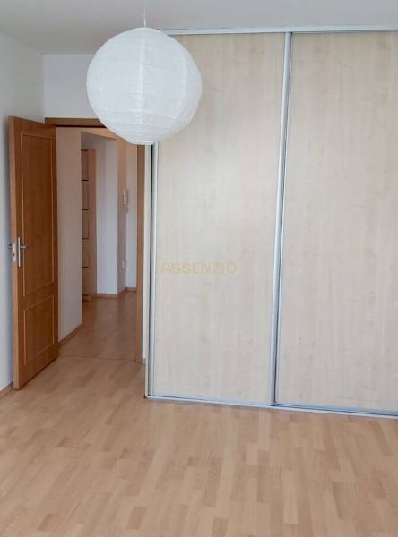 Ein Zimmer in einer 3-Zimmer-Wohnung mit Holzböden und einem Schrank mit Schiebetüren.