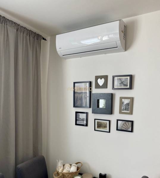 Klimaanlage und gerahmte Fotos an der Wand in einer 3-Zimmer-Wohnung.