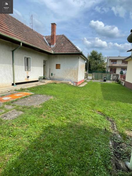 Ein Einfamilienhaus in Trenčianske Stankovce mit gepflegtem Rasen und traditionellem Schrägdach.