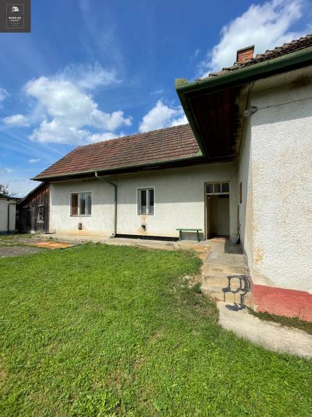 Ein Einfamilienhaus in Trenčianske Stankovce mit Rasen und traditionellem Dach unter blauem Himmel.