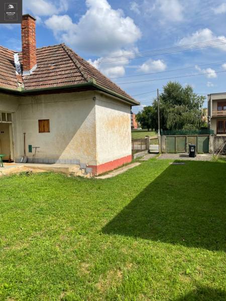 Ein Einfamilienhaus in Trenčianske Stankovce mit einem Rasen-Grundstück und einem Ziegeldach.
