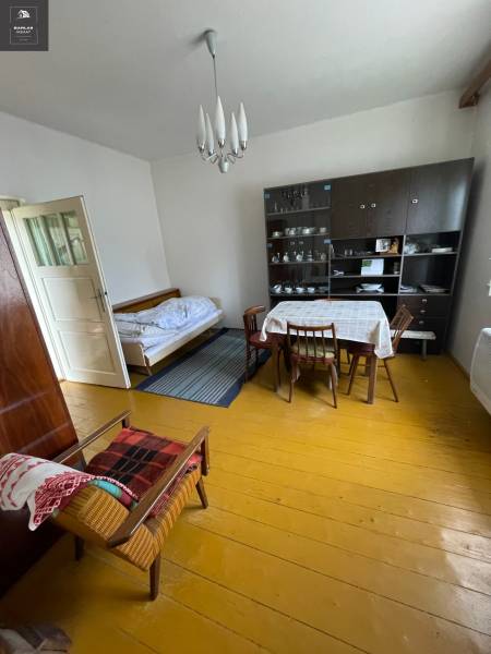 Innenraum eines Einfamilienhauses mit Esstisch, Bett und Vitrine.