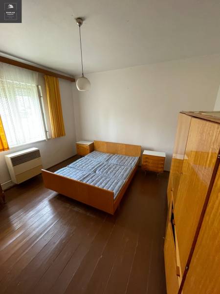 Schlafzimmer in einem Einfamilienhaus mit Holzboden, Bett und Schränken.