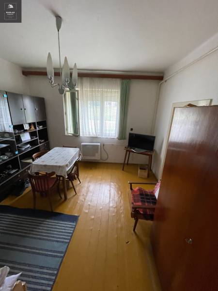 Esszimmer in einem Einfamilienhaus mit Holzboden, einfachem Tisch und Wandschrank.