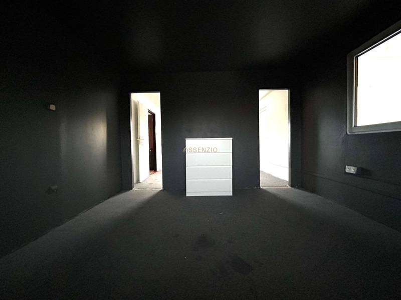 Tmavá izba v 4-izbovom byte s komodou a vstupmi do ďalších miestností.

Dunkles Zimmer in einer 4-Zimmer-Wohnung mit einer Kommode und Eingängen zu weiteren Räumen.