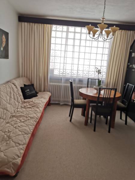 Wohnzimmer mit Sofa, Esstisch und Kronleuchter in einem Einfamilienhaus.