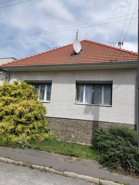 Ein Einfamilienhaus in Topoľčianky mit einem Satteldach und einer Satellitenschüssel.
