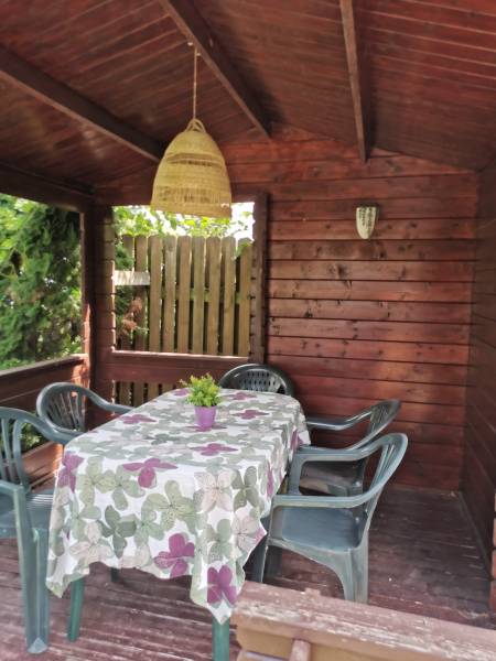 Ein hölzerner Pavillon im Einfamilienhaus in Topoľčianky, mit Plastikstühlen und einem dekorierten Tisch.