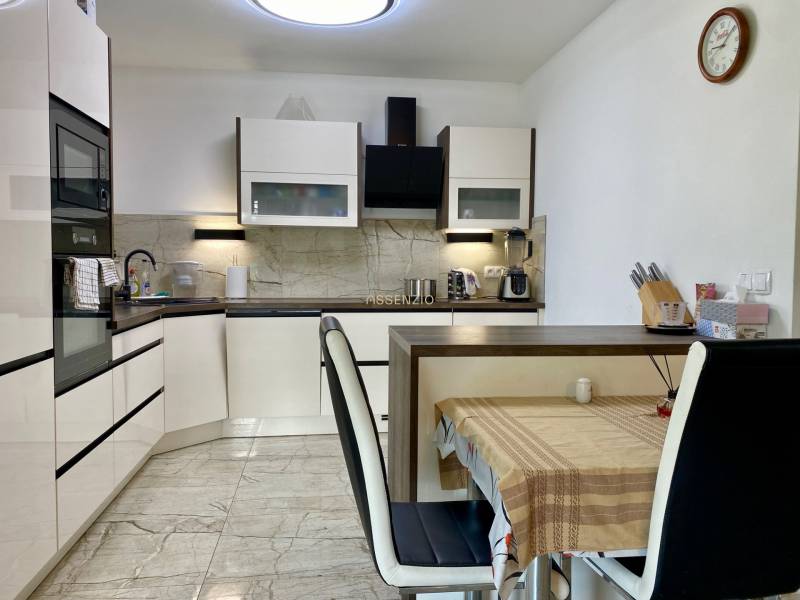 Küche in einem Einfamilienhaus, ausgestattet mit Geräten, Esstisch mit Stühlen.