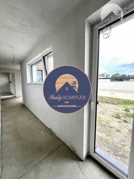 Flur mit Fenstern und Eingang in einem Einfamilienhaus. Auf dem Boden ist Beton.