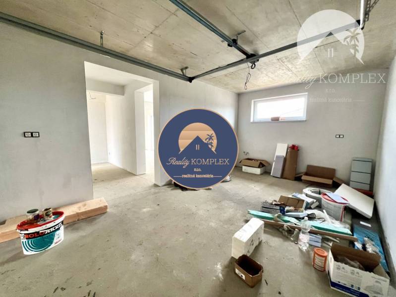 Unvollendetes Interieur eines Einfamilienhauses mit verteiltem Baumaterial und neuen Wänden.