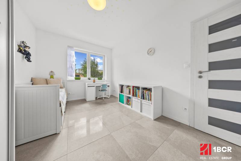 Kinderzimmer im Einfamilienhaus mit Bett, Schreibtisch und Bücherregal.