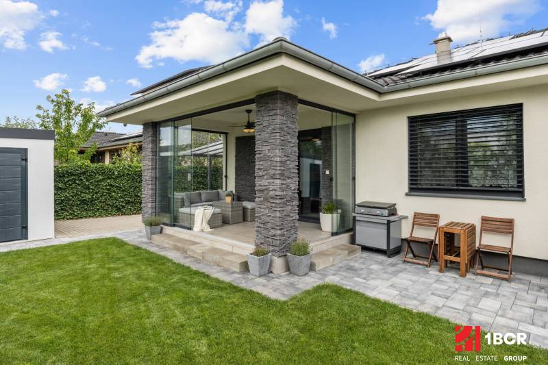 Einfamilienhaus in der Feniklová-Straße in Malinovo, überdachte Terrasse mit Sitzgelegenheit und Grill.