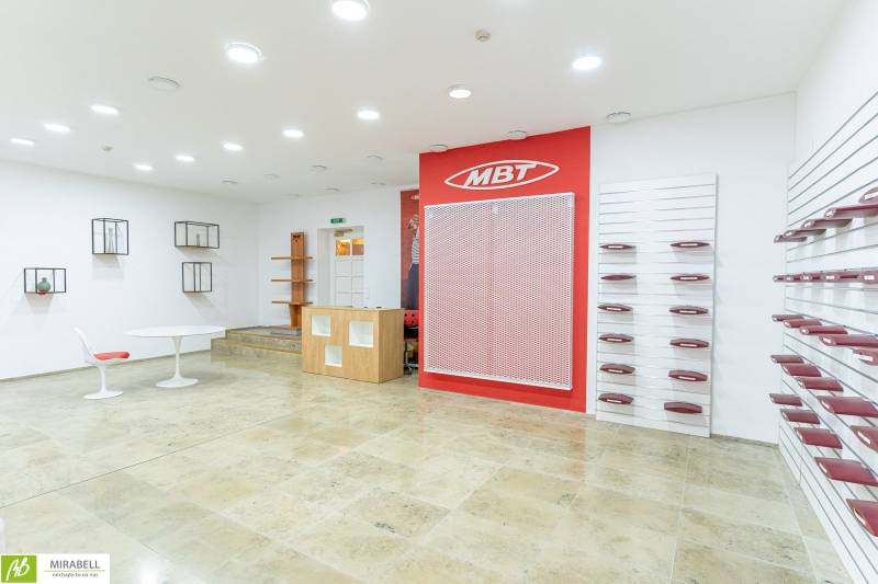 Geräumige Büros mit weißen Wänden, Regalen und roten Accessoires in der Michalská in Bratislava.