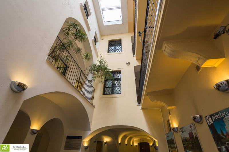 Ein Bürointerieur mit Glasdach, Balkonen und Pflanzen.