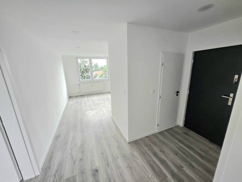 Ein heller Flur und Boden in einer 3-Zimmer-Wohnung mit einem großen Fenster.