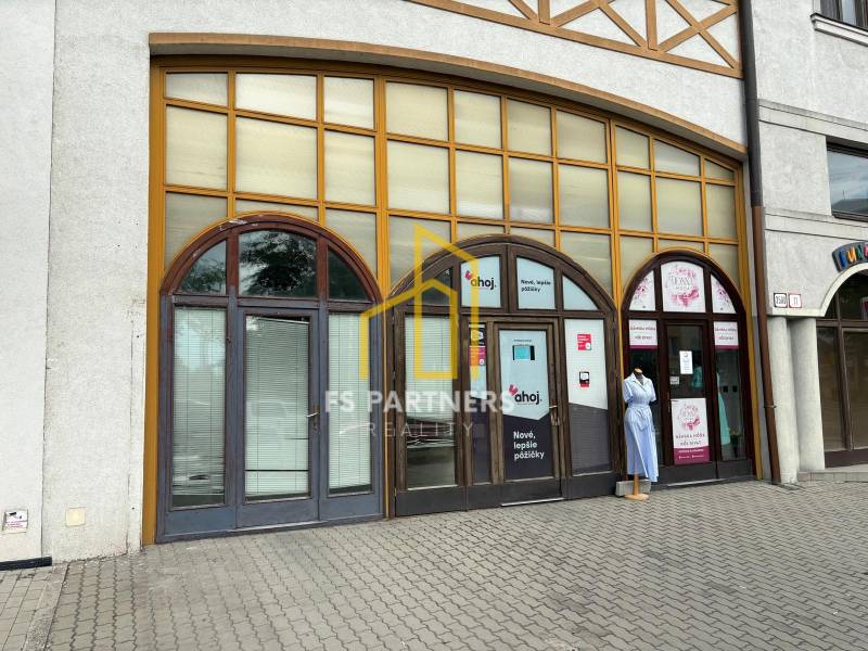 Geschäftsräume in der Petöfi-Straße in Komárno mit großen Fenstern und einer Schaufensterpuppe.