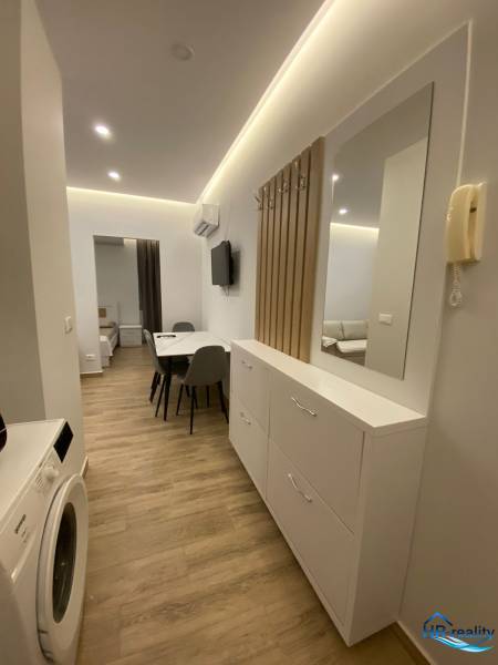 Der Flur der Ferienwohnung mit Waschmaschine, Spiegel und Esstisch.