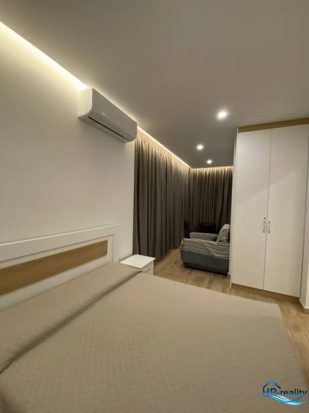 Ferienwohnung mit Bett, Schrank, Klimaanlage und Sofa.