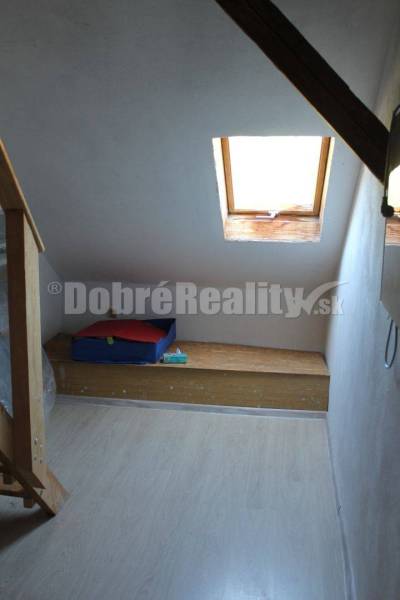 Dachbodenraum in einem Einfamilienhaus mit Dachfenster und Holzbank.