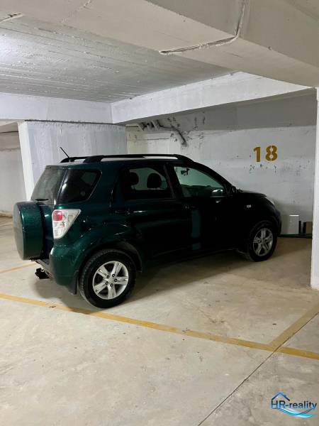 Das Auto ist in der Garage auf dem Parkplatz Nummer 18 geparkt.