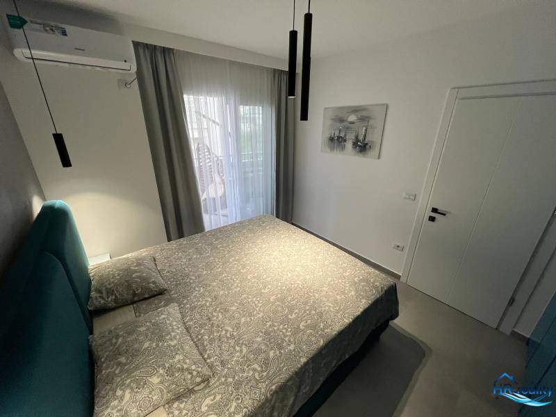 Ferienwohnung mit bequemem Bett, Klimaanlage und Balkontüren mit Aussicht.