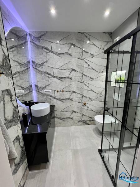 Badezimmer in einer Ferienwohnung mit Designer-Waschbecken und Duschkabine.