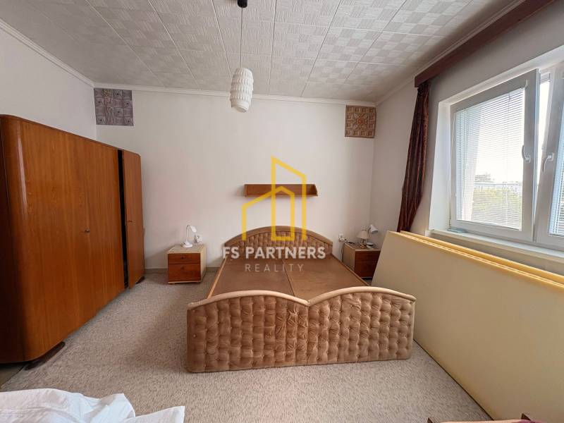 Schlafzimmer in einem Einfamilienhaus mit einem großen Bett und Holzschränken.