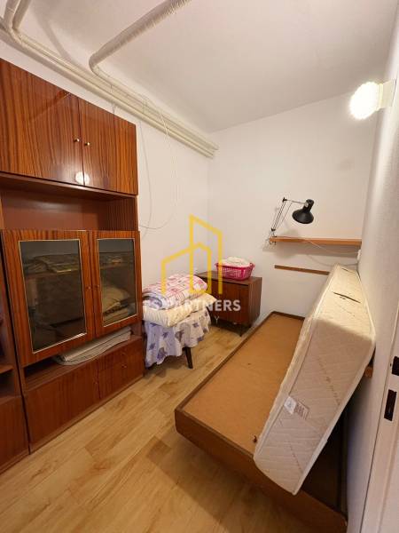 Ein kleiner Raum mit antiken Möbeln und einem ausziehbaren Bett in einem Einfamilienhaus.