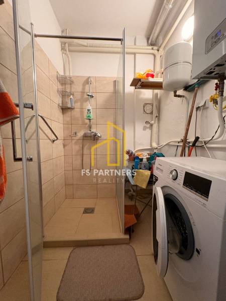 Badezimmer mit Waschmaschine und Duschkabine im Einfamilienhaus.