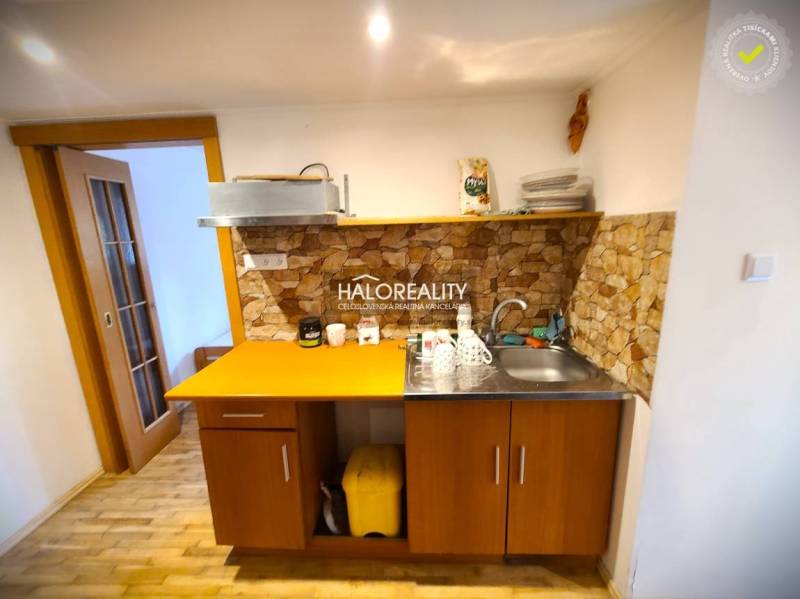 Eine Küche in einem Einfamilienhaus mit Holzmöbeln und Steinverkleidung.