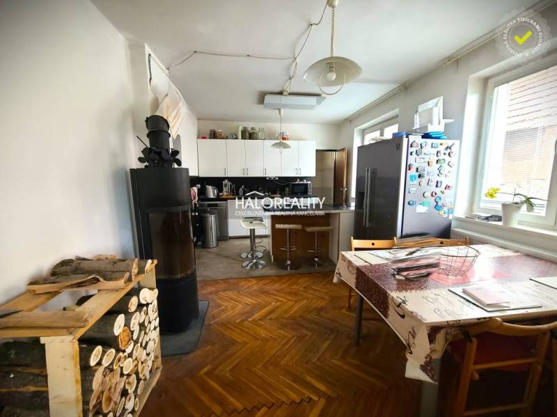 Küche eines Einfamilienhauses mit Herd, Esstisch und Kühlschrank auf einem bunten Boden.