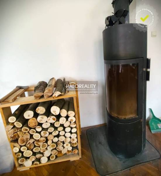 Ein Einfamilienhaus mit Kamin und einem Vorrat an Holz zum Heizen.