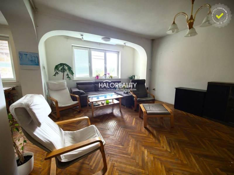 Wohnzimmer in einem Einfamilienhaus mit Sesseln und einem braunen Sofa.