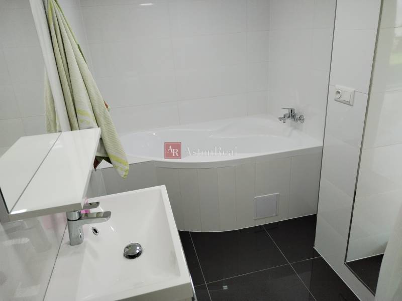 Ein Badezimmer in einem Einfamilienhaus mit einer Dusche und einem dunklen Boden.