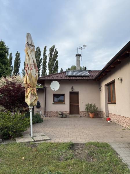 Einfamilienhaus in Malacky, Vorgarten mit Terrasse, Grünfläche und Satellitenschüssel.