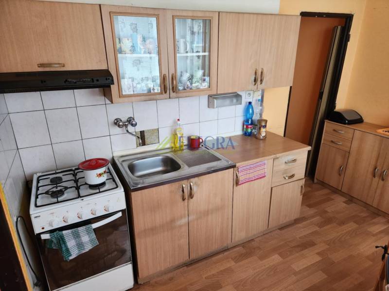 Küche in einer Einzimmerwohnung mit Holzschränken und einem Gasherd.
