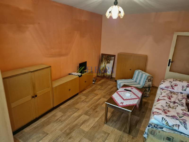 Ein Zimmer mit Holzmöbeln und einem Sessel in einer Einzimmerwohnung.
