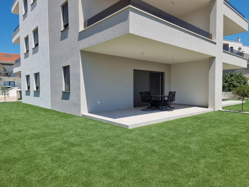 Exterieur einer 4-Zimmer-Wohnung in Vodice mit moderner Terrasse und grünem Rasen.